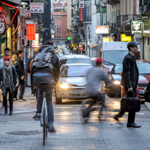 Calle con diferentes personas moviéndose por la ciudad al día con la actualidad y leyendo sus blog en el móvil.