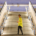 Hombre con camisa amarilla de pie en unas escaleras iluminadas en una estación moderna, destacando el contraste entre la arquitectura y el individuo. Ideal para temas de comunicación y narrativa digital