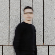 Imagen conceptual de comunicación sostenible con persona desenfocada caminando frente a un muro de piedra, simbolizando el movimiento hacia un futuro más consciente y humano.